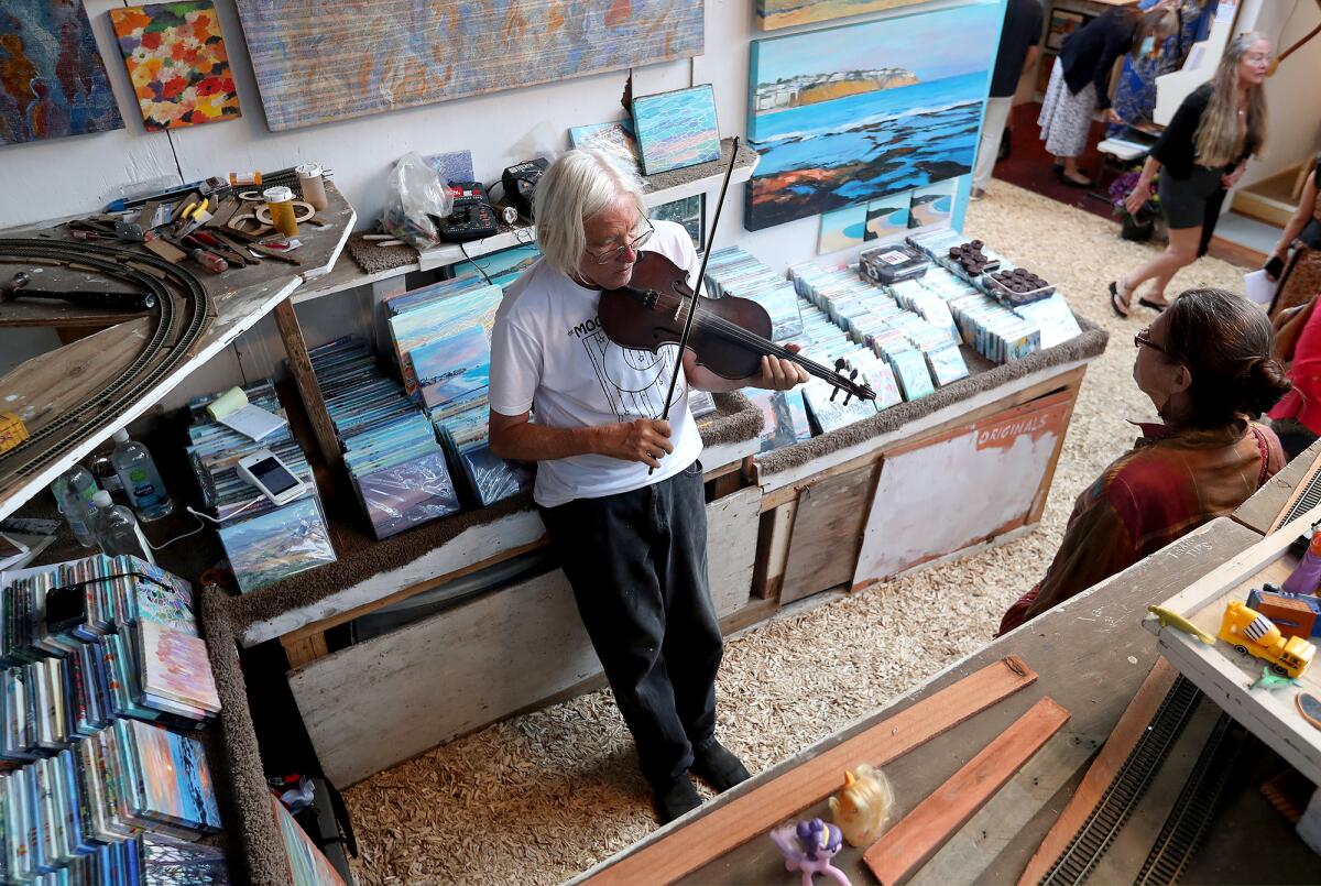 Longtime exhibitor and musician Douglas Miller plays his violin during the 2022 Sawdust Festival in Laguna Beach.