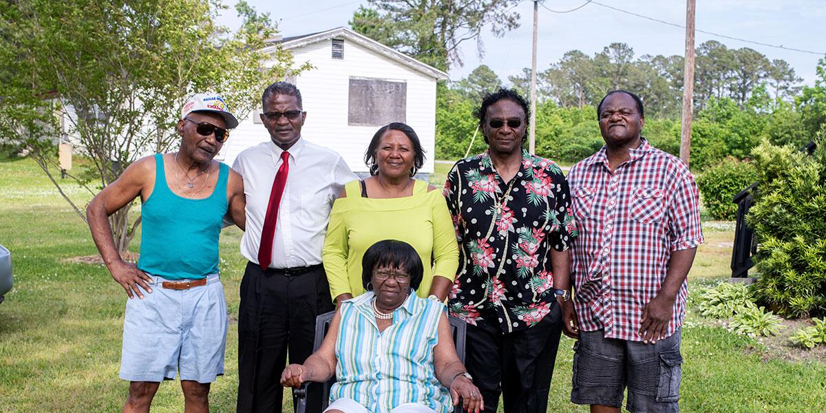 Six members of a family pose outdoors for a photo in a scene from the documentary "Silver Dollar Road."