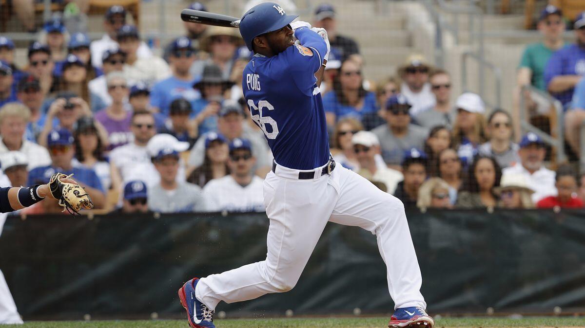 Dodgers outfielder Yasiel Puig hits a home run Sunday against the Seattle Mariners in the fourth inning of a spring training game at Camelback Ranch.