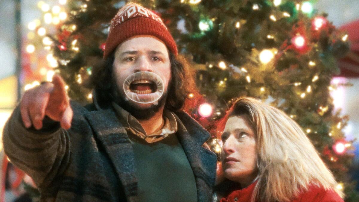 A woman looks at a man with a distorted mouth