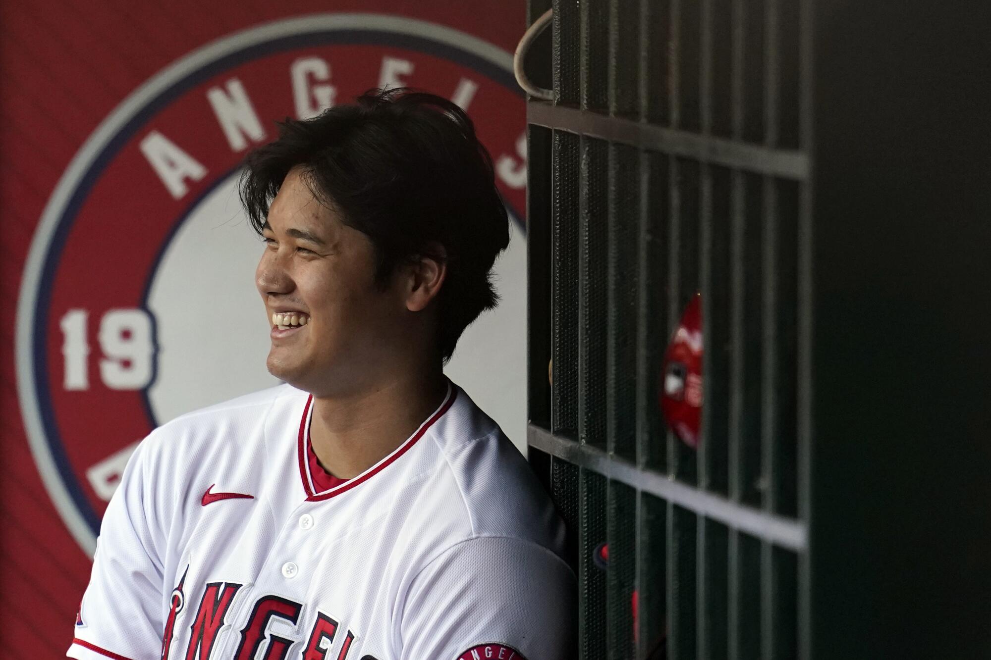 Angels' Shohei Ohtani smiles in the dugout during a game against the Texas Rangers