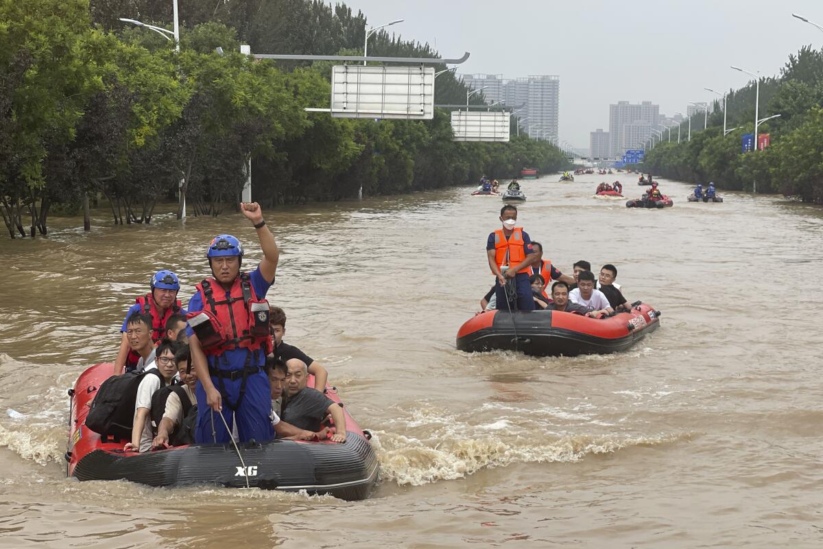 Residents are evacuated in rubber boats through floodwaters in Zhuozhou south of Beijing.