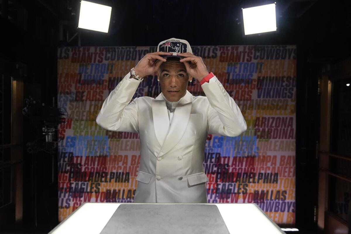 Oregon defensive back Christian Gonzalez puts on a hat after being chosen by the New England Patriots.