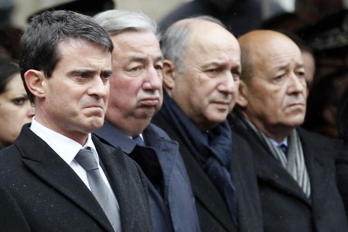 French Prime Minister Manuel Valls, left, and other officials attend a ceremony Jan. 13 to pay tribute to three police officers killed in the recent terror attacks in Paris.