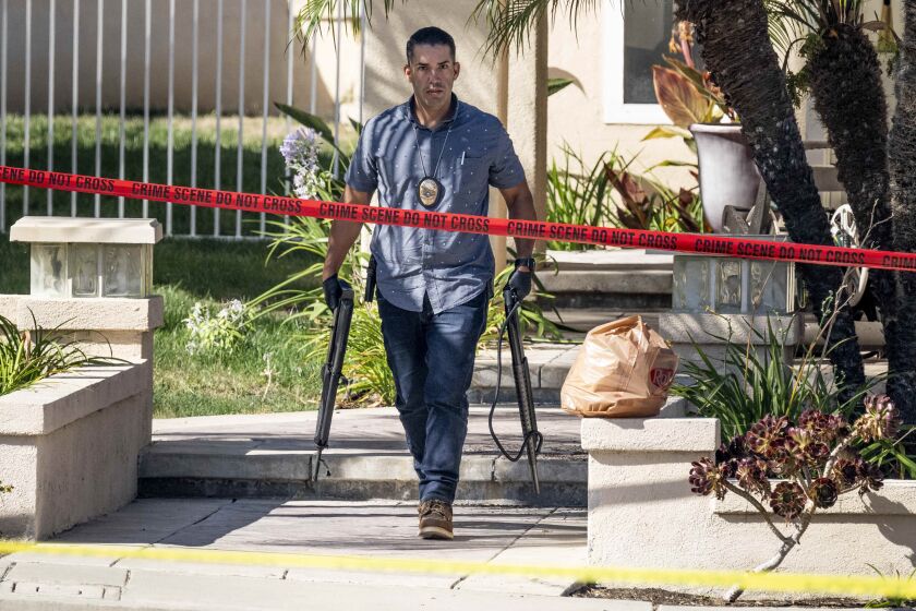Investigadores retiran armas de fuego de una casa en la cuadra 8500 de E. Canyon Vista Dr. en Anaheim, California, el viernes 4 de agosto de 2023. (Paul Bersebach/The Orange County Register vía AP)