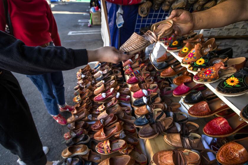 BOYLE HEIGHTS, CA - NOVEMBER 11, 2020: Women's handmade leather huaraches are on display at "Mas Sport" located in the parking lot at El Merdado de Los Angeles in Boyle Heights. For the past 22 years, Maria Silva has sold huaraches and other hand-crafted Mexican footwear in her shop, "Mas Sport" inside Boyle Heights El Mercado do Los Angeles. But when the pandemic hit, her livelihood suddenly vanished. After forcing to close shop for five months, during which she received zero financial assistance, Silva resorted to solely selling huaraches in El Mercado's parking lot where vendors were given the green light to reopen in late August. (Mel Melcon / Los Angeles Times)