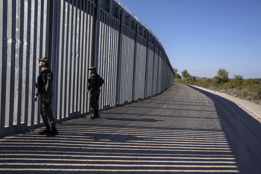 FILE - Police border guards patrol along a border wall near the town of Feres, along the Evros River which forms the the frontier between Greece and Turkey, on Sunday, Oct. 30, 2022. Greece's prime minister promised to extend a wall across all of the country's land border with Turkey during a campaign stop on Friday, March 31, 2023, ahead of a general election. (AP Photo/Petros Giannakouris, File)