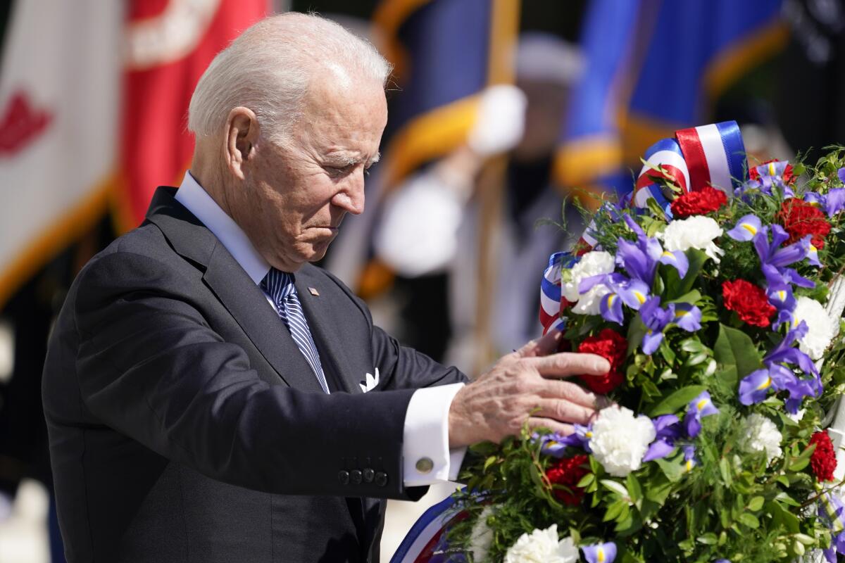 President Biden adjusts a wreath 