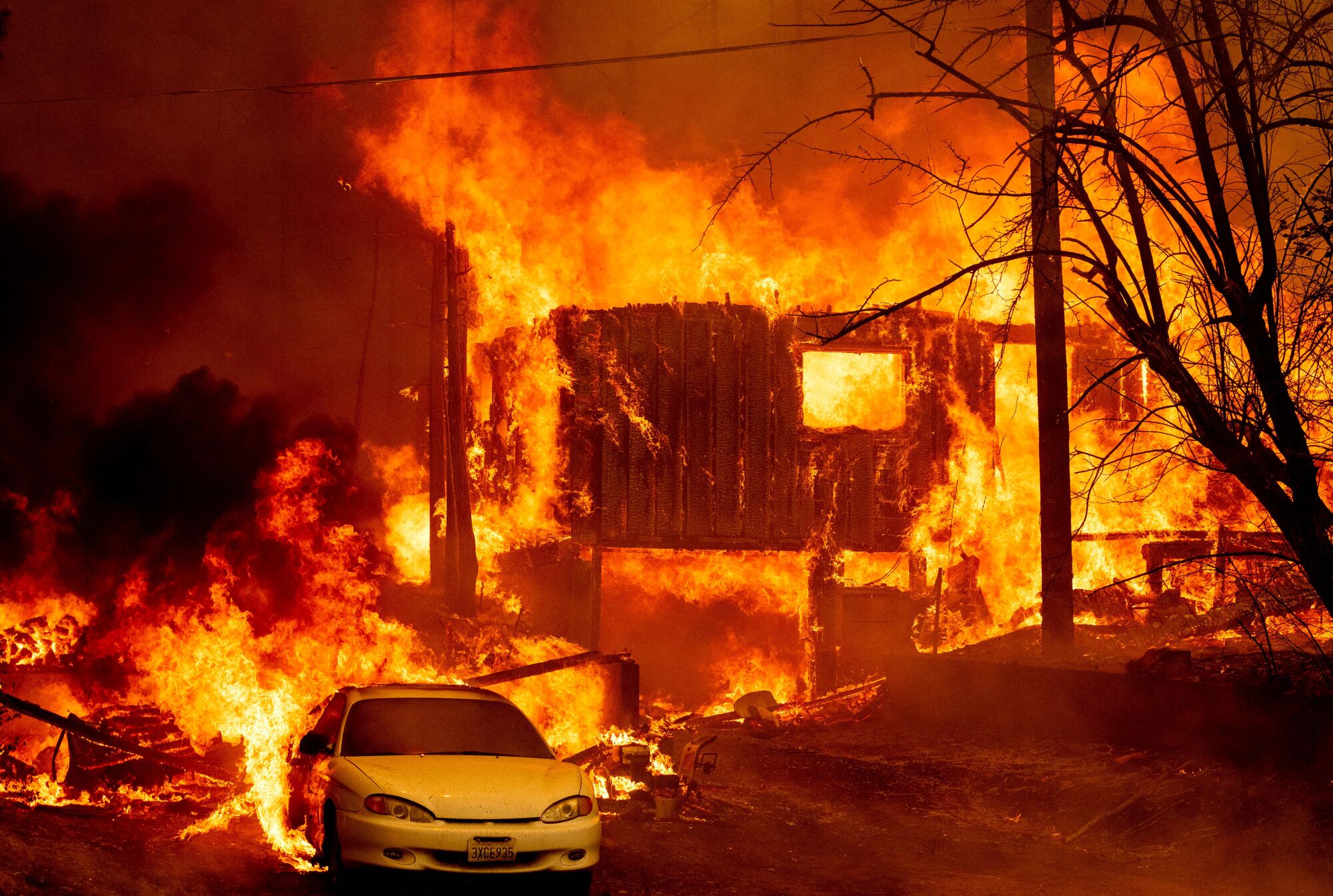 After dark, flames leap and devour a home and a car.