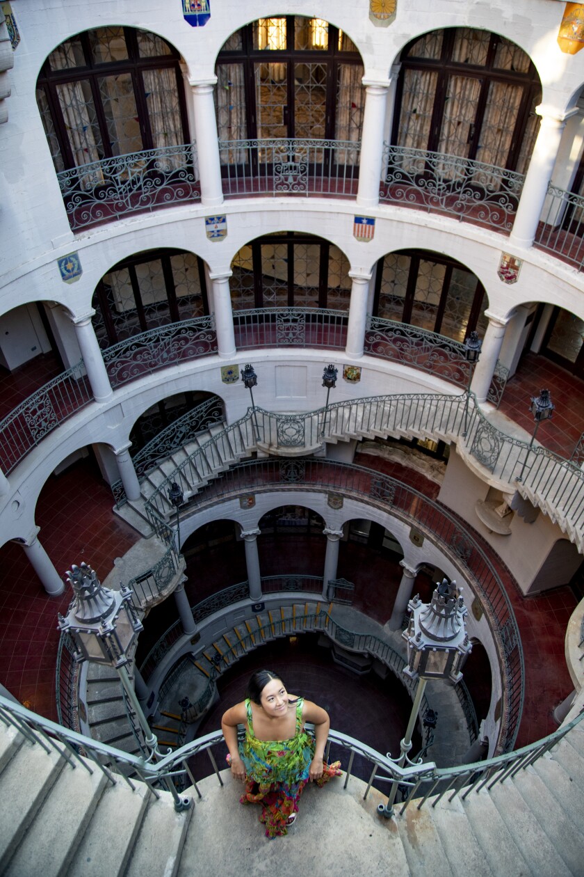 A woman in a colorful dress takes in the view of the circular stairs at the Mission Inn in Riverside, California.