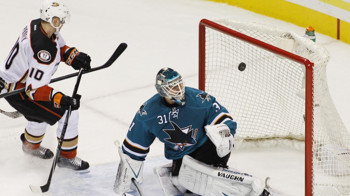 San Jose Sharks goalie Antti Niemi blocks a shot in front of Anaheim forward Corey Perry during the Ducks' 6-4 loss Saturday.