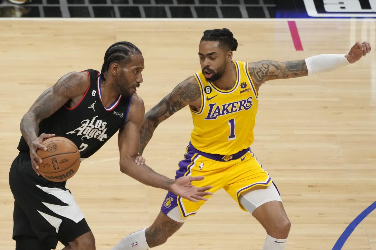 Clippers forward Kawhi Leonard, left, tries to drive past Lakers guard D'Angelo Russell.