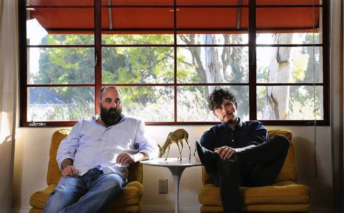 Artists Charlie White, left, and Brayn Hollon in the living room of Hollon's home in South Pasadena.