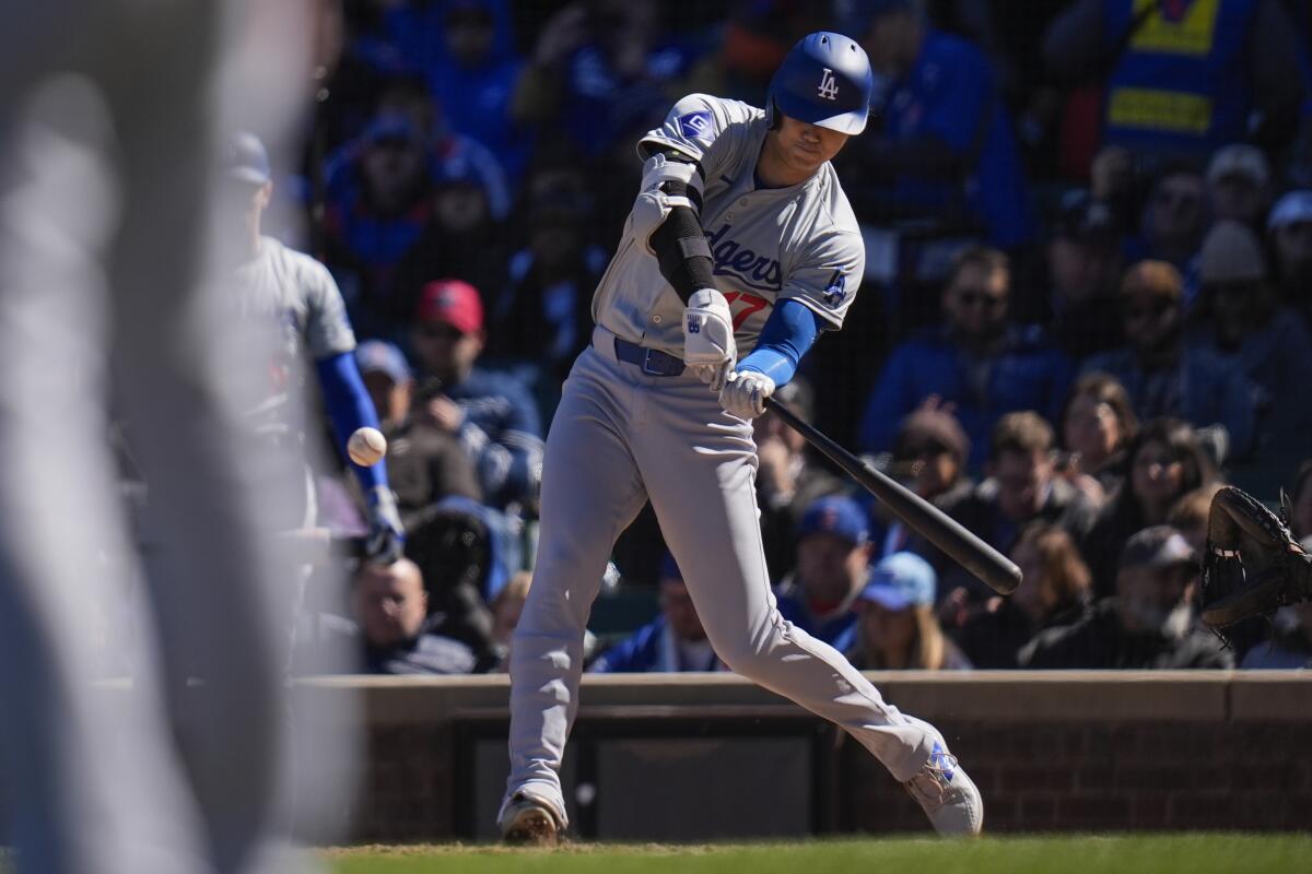 The Dodgers' Shohei Ohtani hits a home run during the fifth inning of Friday's game against the Cubs in Chicago.