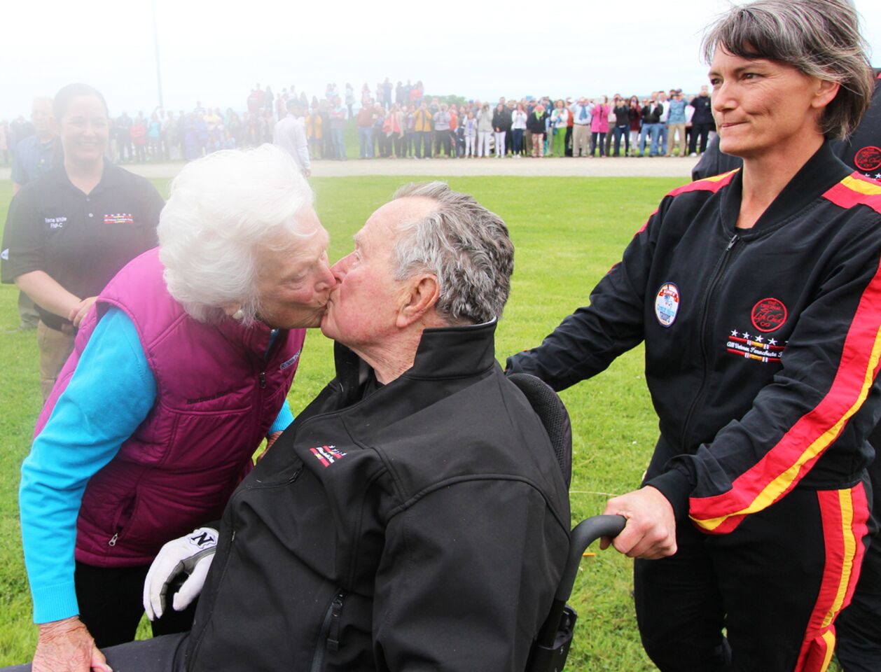 Barbara Bush kisses former President George H.W. Bush after his parachute landing on his 90th birthday in Kennebunkport, Maine, on June 12, 2014.