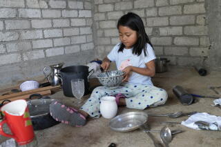 a 5-year-old girl sits on the grounds with old bowns and pitchers