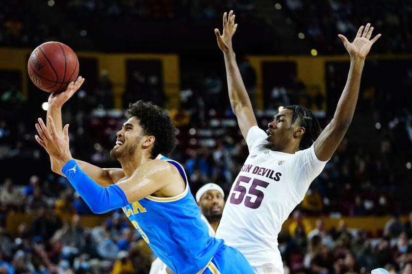 UCLA's Johnny Juzang, left, is fouled by Arizona State's Jamiya Neal during the first half Feb. 5, 2022.