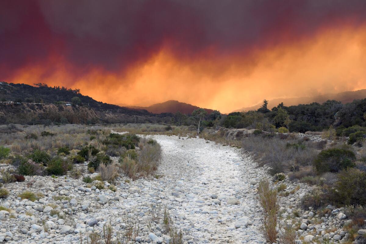 Smoke from the Thomas fire crosses over the dry Ventura River in Ojai.