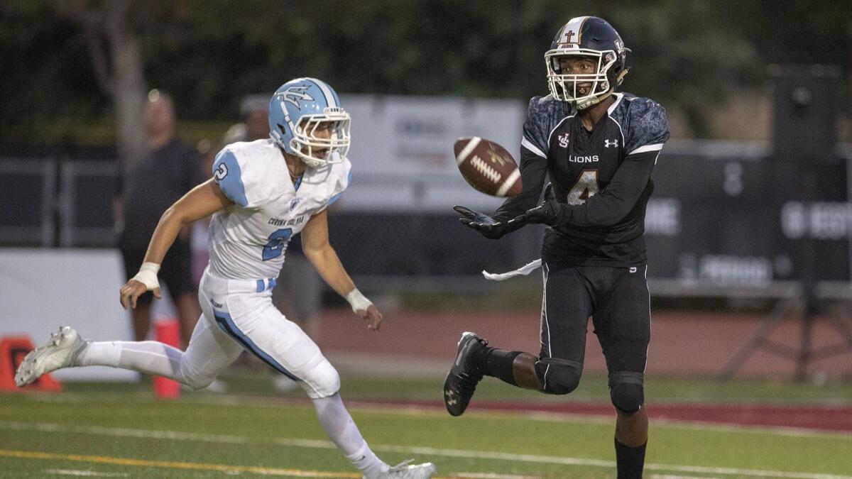 JSerra High's Tarik Luckett gets by Corona del Mar's Jack Elliott and catches a pass across the middle that goes for a 50-yard touchdown in the second quarter on Friday.