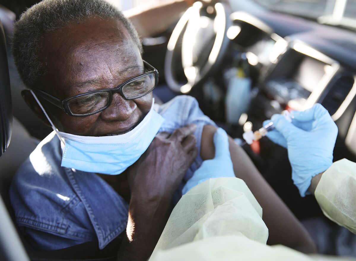 Patricia Martin receives a drive-through flu shot in her car in Tulsa, Okla.