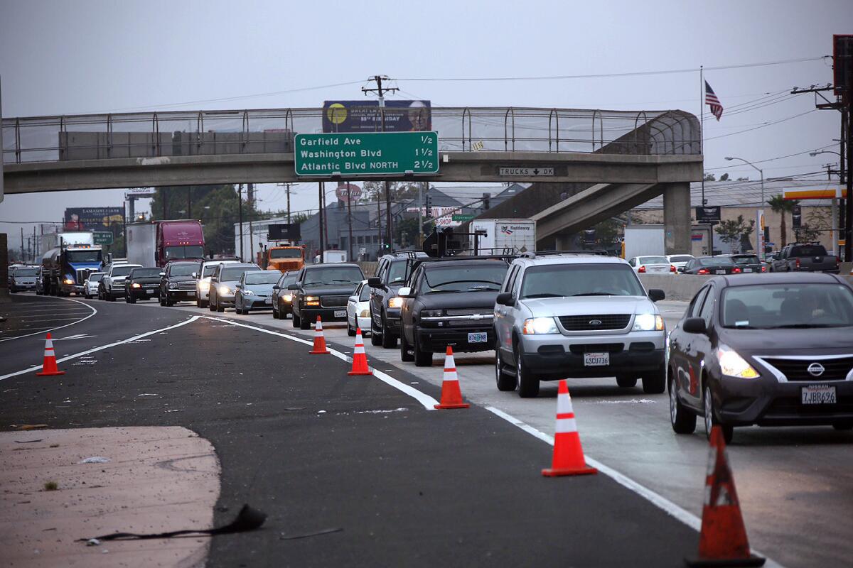 Commuters on Tuesday morning utilize the one lane of the southbound 5 Freeway that reopened in the City of Commerce, more than five hours after a fire broke out along a riverbed and snarled traffic on both sides of the busy roadway.