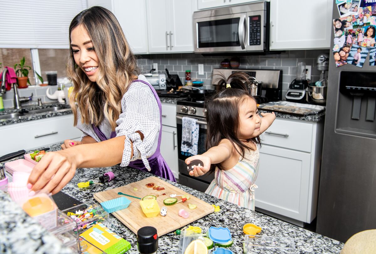 While preparing a bento box, Jessica Woo and daughter Olive have fun in the kitchen.