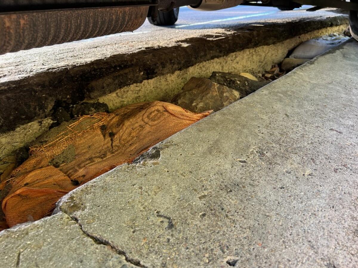 A deep pothole along the north side of La Jolla Shores Drive, pictured in June, was temporarily filled with sandbags.