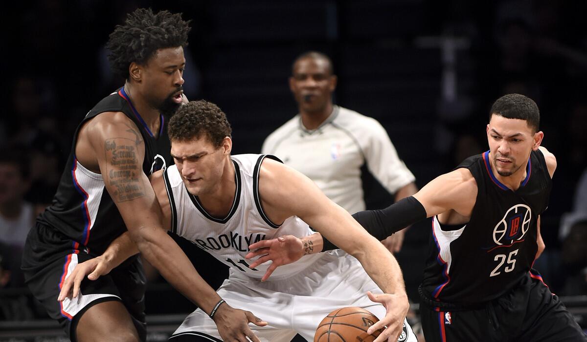 Brooklyn Nets center Brook Lopez, center, drives the ball against Clippers center DeAndre Jordan, left, and guard Austin Rivers during the first half on Saturday.