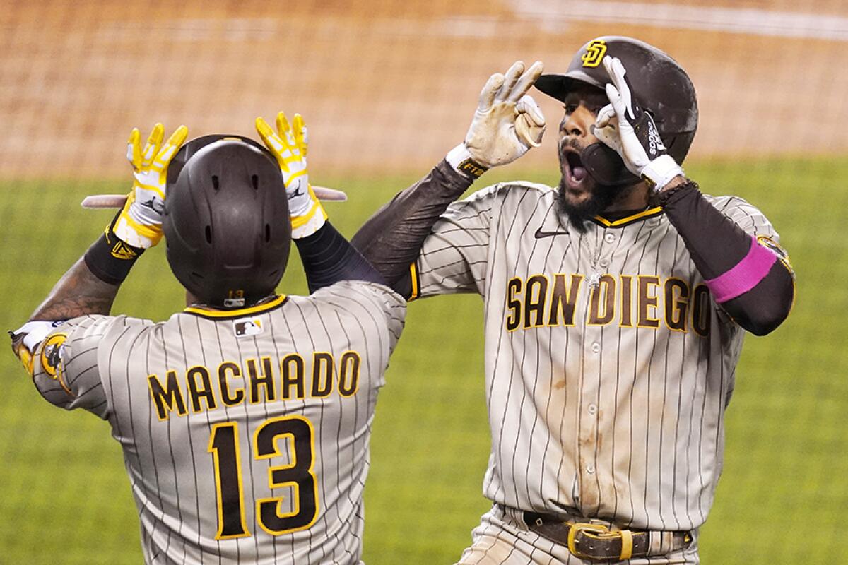 The Padres' Fernando Tatis Jr. celebrates his third-inning home run with Manny Machadot.