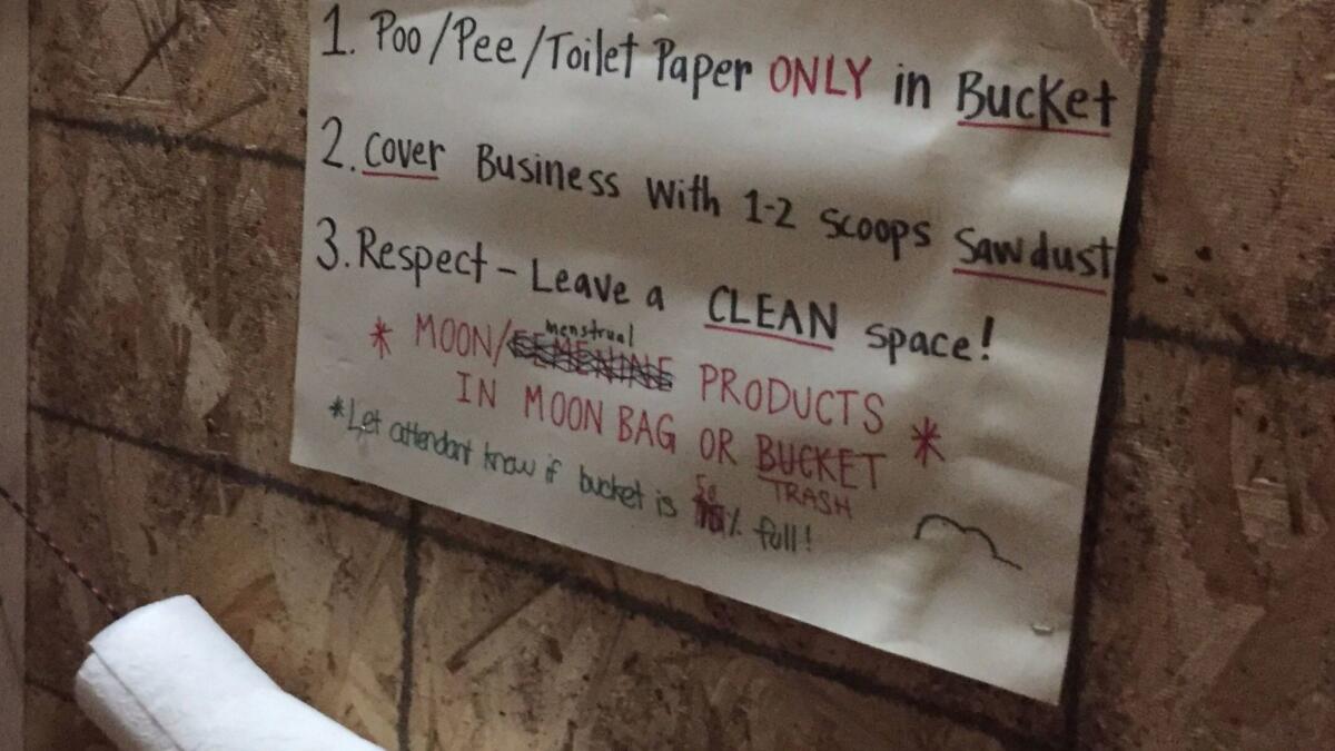 Signs next to a composting toilet at the Standing Rock protest camp offer directions for use.