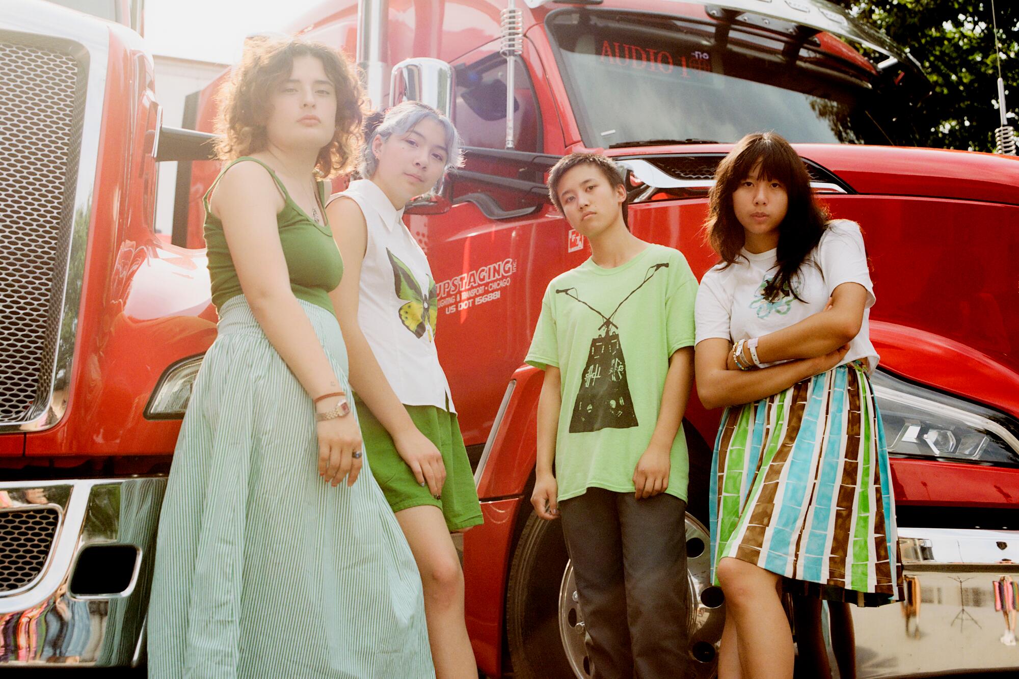 Four teenage girls posing in front of a big red semi-truck