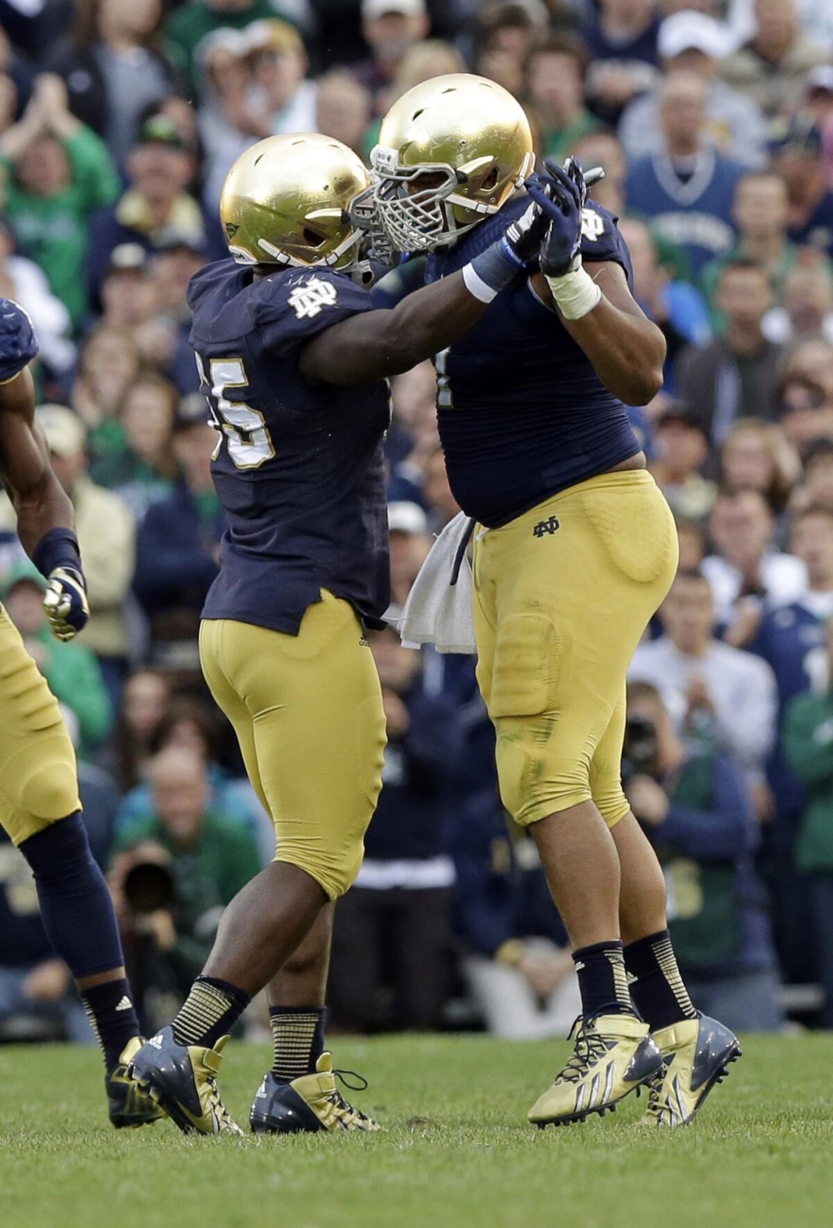 Notre Dame defensive linemen Prince Shembo, left, and Stephon Tuitt celebrate a sack in a win over Michigan State last week. Will the Fighting Irish pull off a win Saturday against Oklahoma?