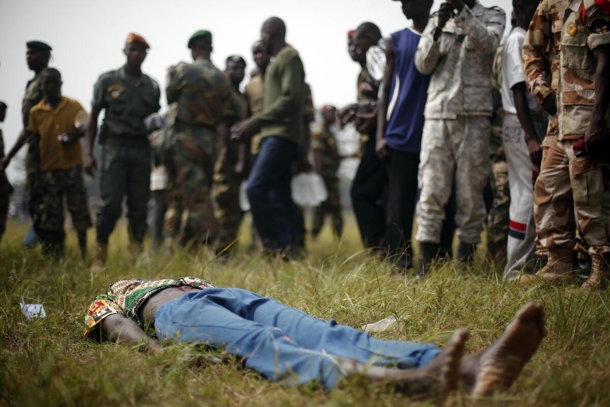 A man accused of being a former rebel lies wounded on the ground after being attacked by soldiers at an event in the Central African Republic capital, Bangui. The man was killed within minutes, witnesses said.