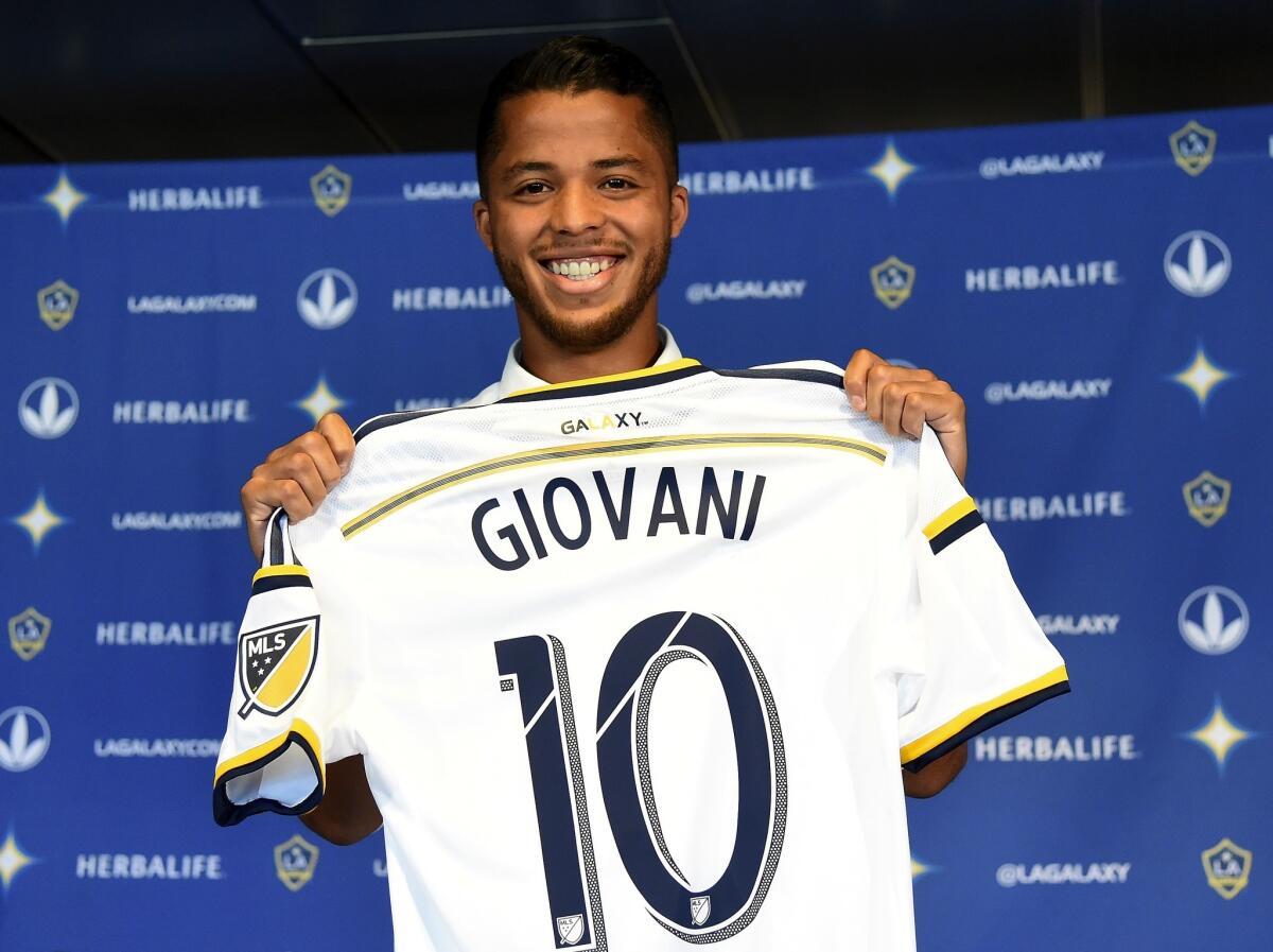 Giovani Dos Santos #10 of the Los Angeles Galaxy holds up his new jersey at a press conference at StubHub Center on August 4, 2015 in Carson, California.