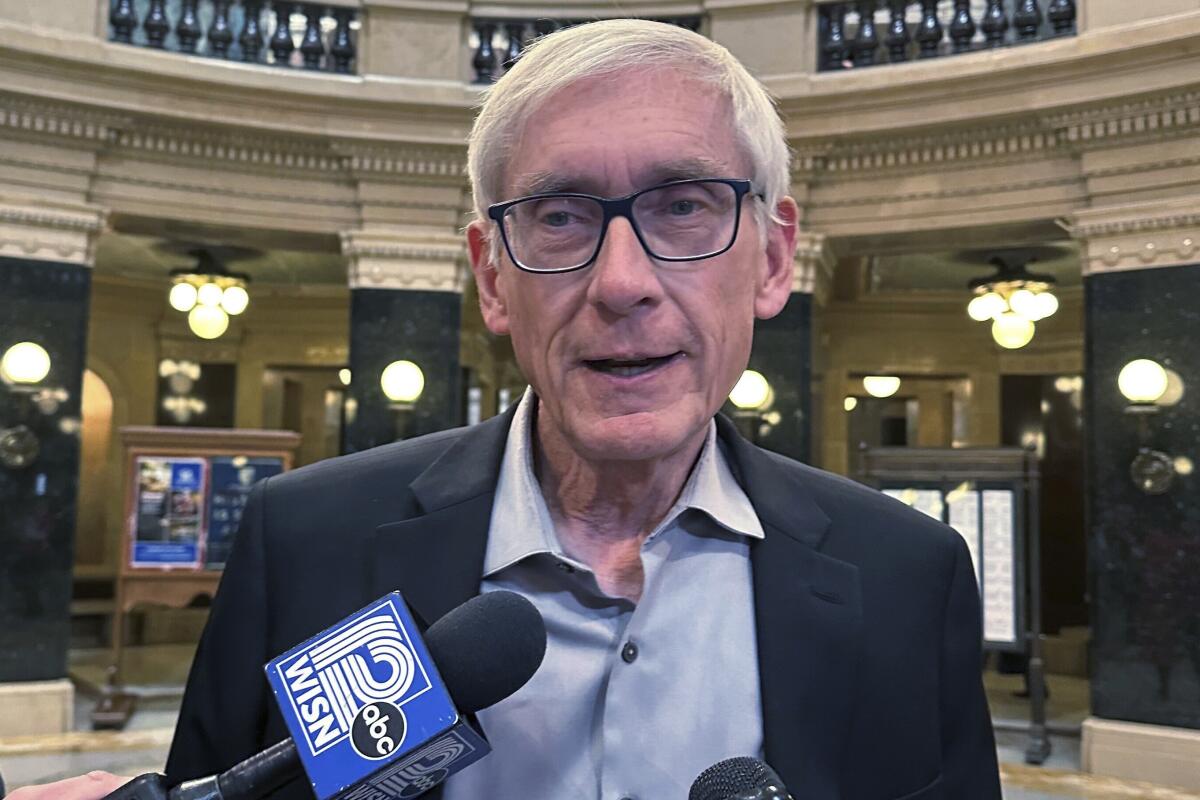 Wisconsin Gov. Tony Evers speaks with eporters in the state Capitol in Madison, Wis.