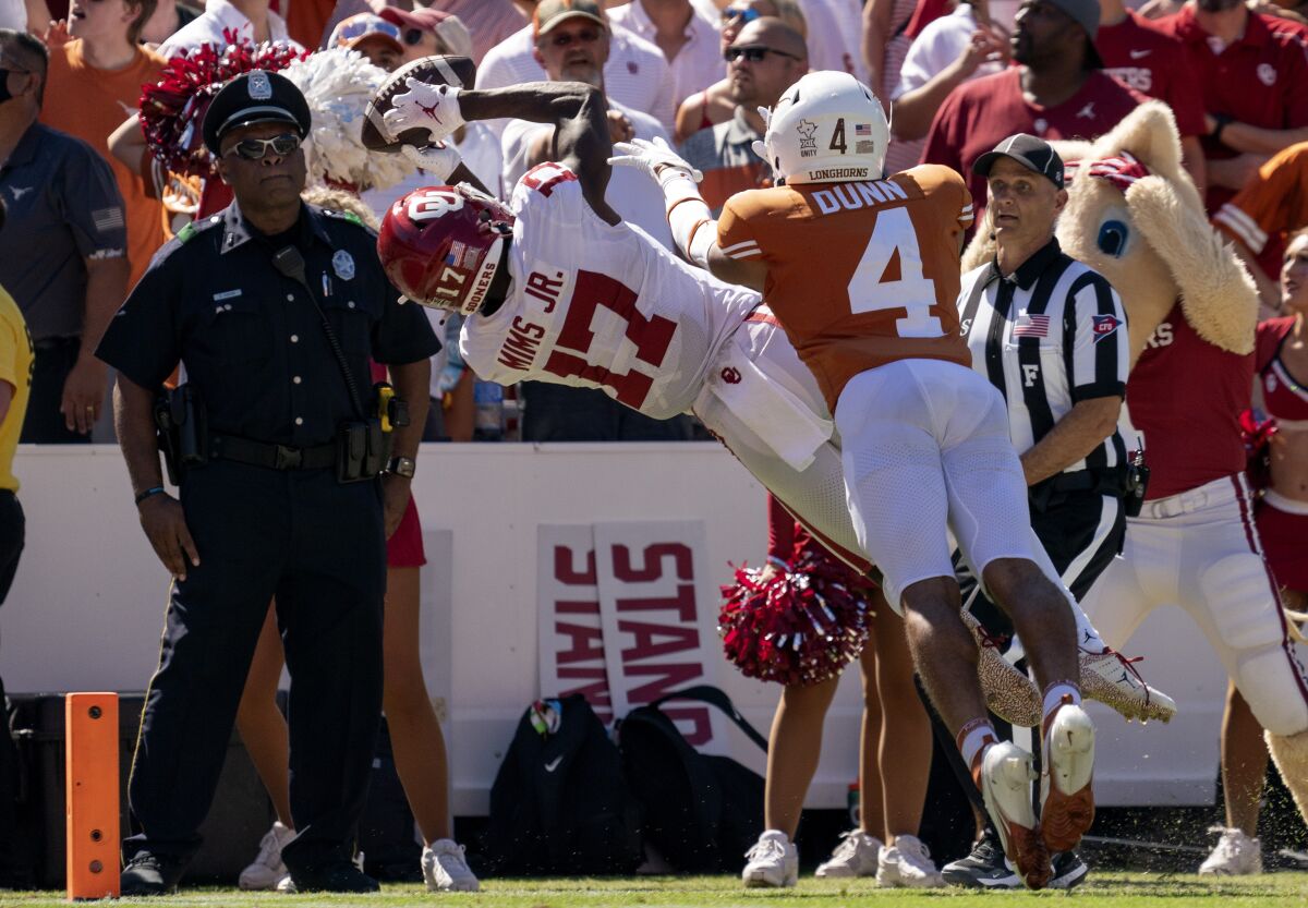 Oklahoma wide receiver Marvin Mims (17) makes a diving catch for a touchdown in front of Texas defensive back Darion Dunn (4) during the fourth quarter of an NCAA college football game at the Cotton Bowl, Saturday, Oct. 9, 2021, in Dallas. (AP Photo/Jeffrey McWhorter)