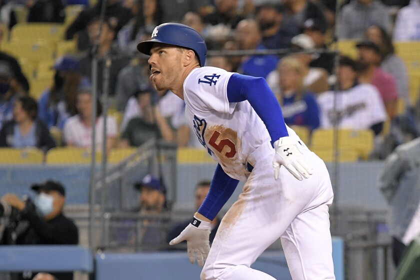 Los Angeles Dodgers' Freddie Freeman drops hit bat as he hits a solo home run.