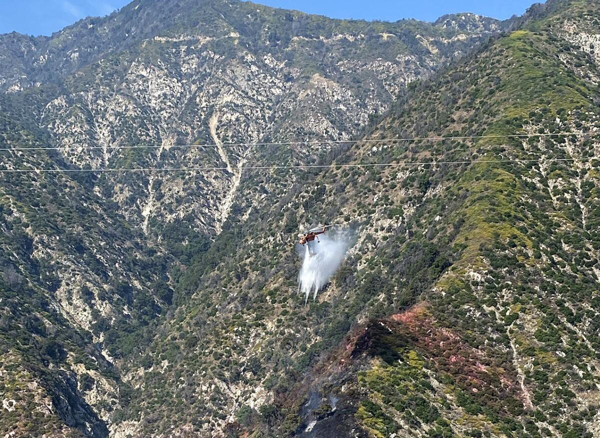 A helicopter drops retardant on a slow-moving blaze called the Chantry fire in Santa Anita Canyon