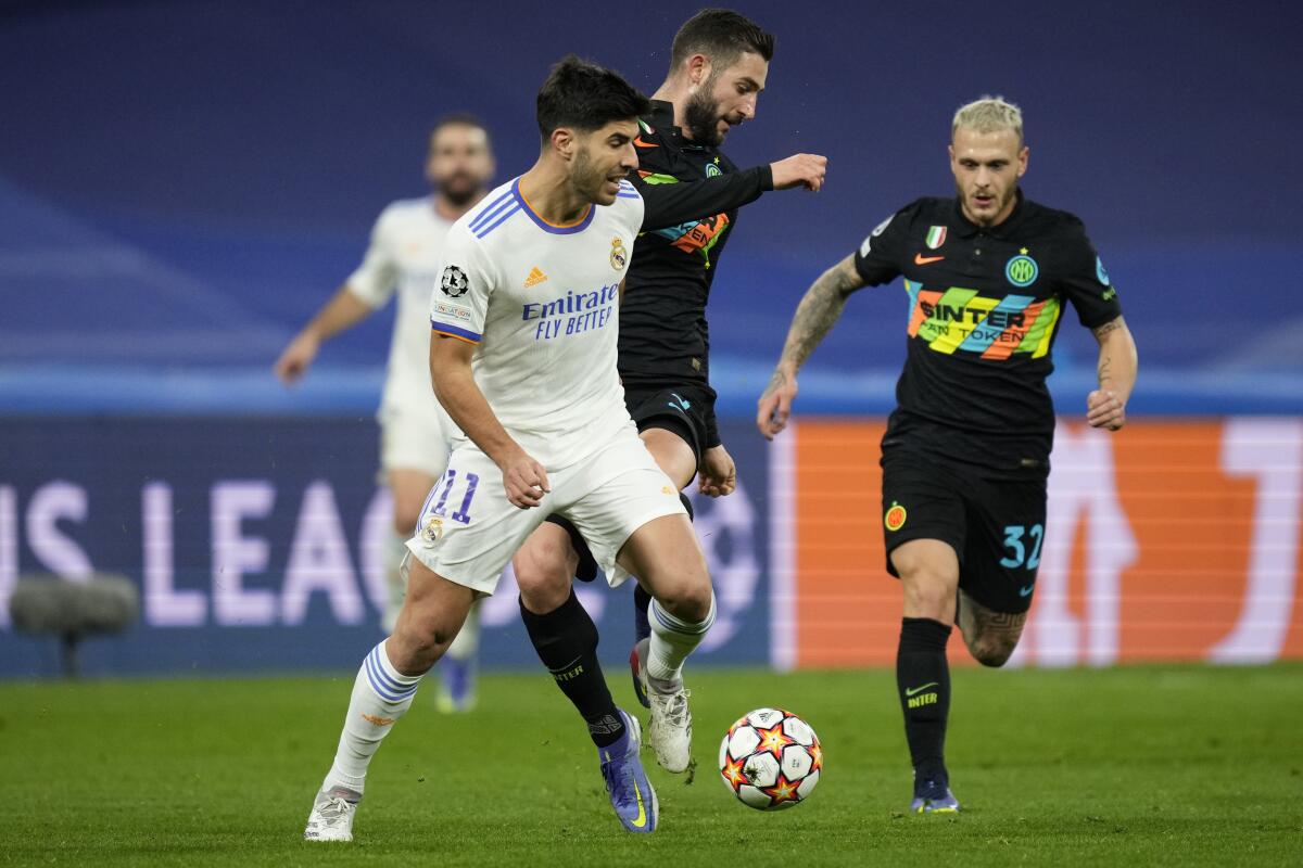 Real Madrid's Marco Asensio, left, vies for the ball with Inter Milan's Roberto Gagliardini during the Champions League Group D soccer match between Real Madrid and Inter Milan at the Santiago Bernabeu stadium, in Madrid, Spain, Tuesday, Dec. 7, 2021. Asensio scored once in Real Madrid's 2-0 victory. (AP Photo/Bernat Armangue)