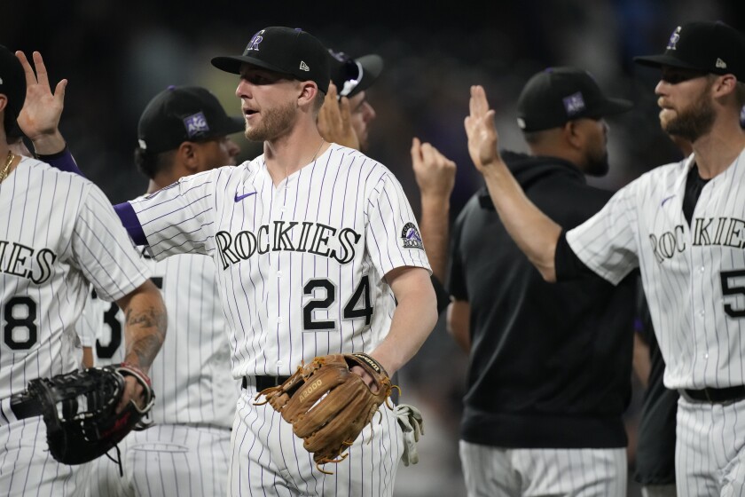 Colorado Rockies third baseman Ryan McMahon (24) and teammates congratulate one another after an 8-4 win over the San Diego Padres in a baseball game Tuesday, June 15, 2021, in Denver. (AP Photo/David Zalubowski)