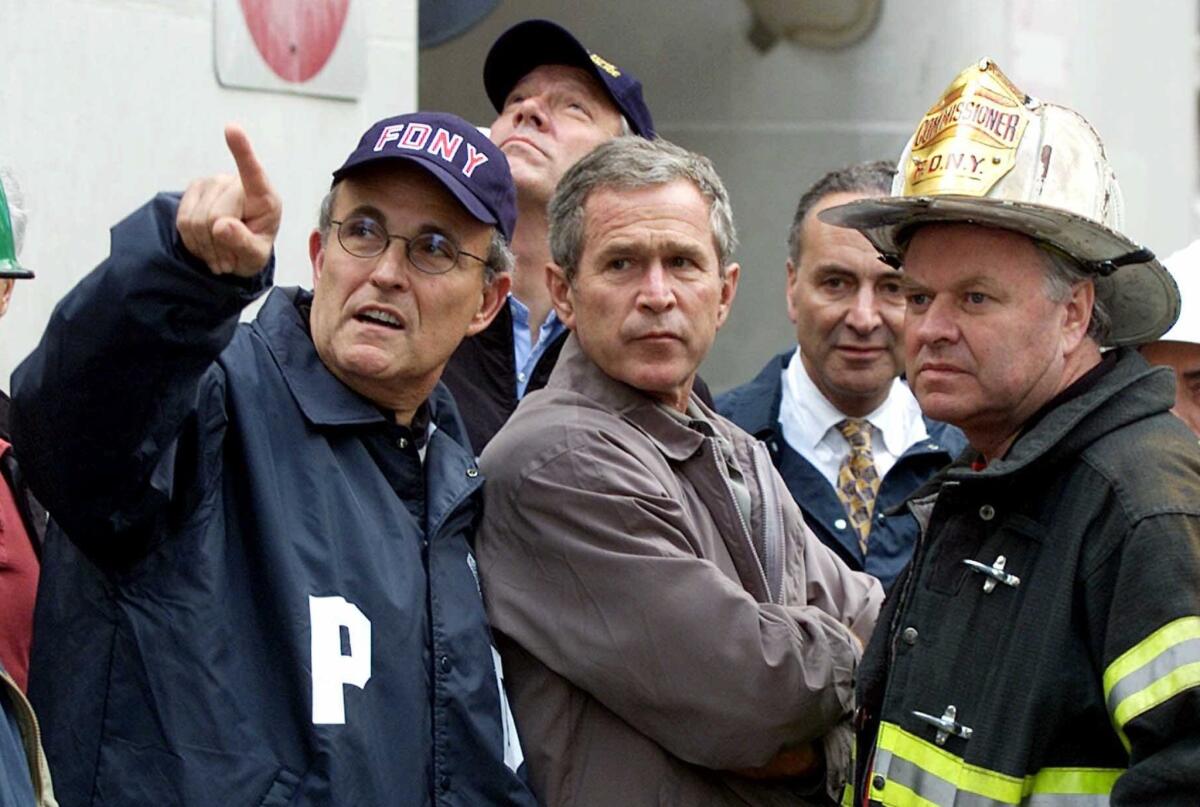 New York Mayor Rudy Giuliani, left, with President George W. Bush and Fire Commissioner Thomas Van Essen on Sept. 14, 2001