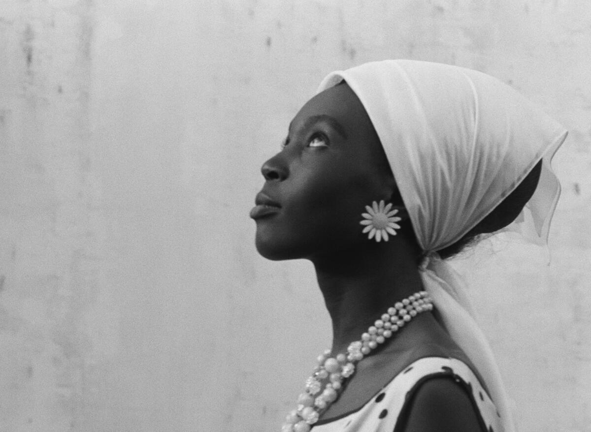 A woman in a headscarf looks upward.