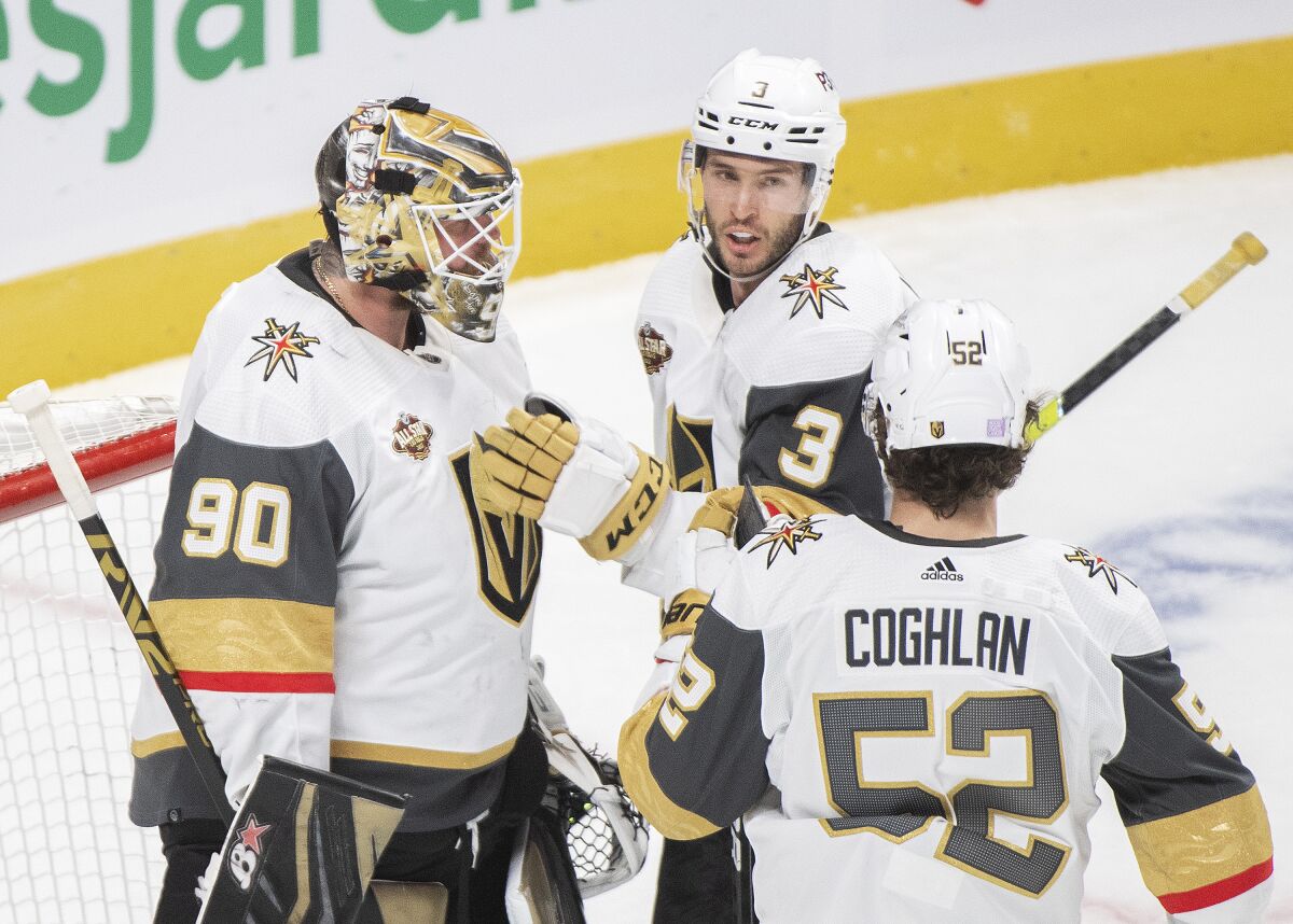 Vegas Golden Knights goaltender Robin Lehner (90) is congratulated by teammates Brayden McNabb (3) and Dylan Coghlan (52) after defeating the Montreal Canadiens in an NHL hockey game in Montreal, Saturday, Nov. 6, 2021. (Graham Hughes/The Canadian Press via AP)