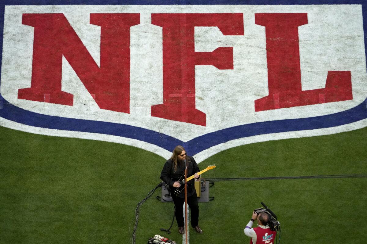 Chris Stapleton performs in front of the NFL logo.