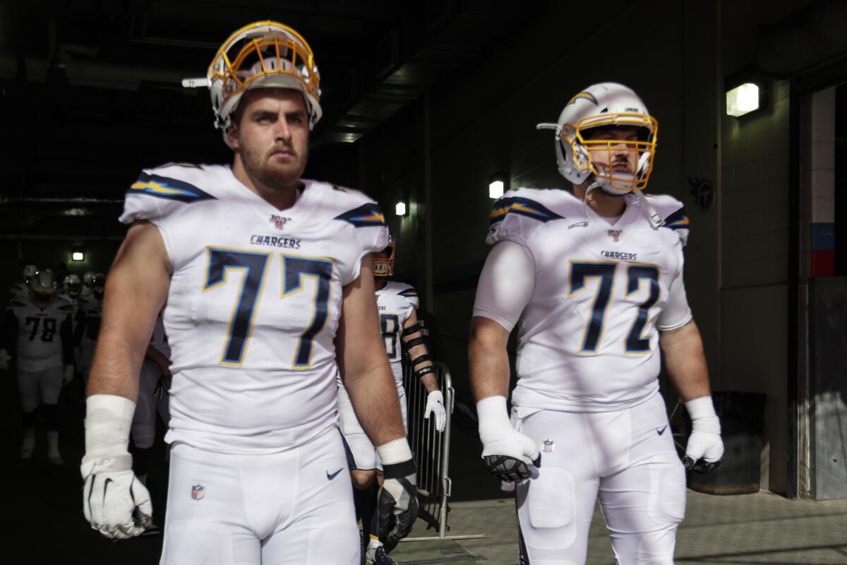 Chargers linemen Forrest Lamp (77) and Ryan Groy enter the field. 