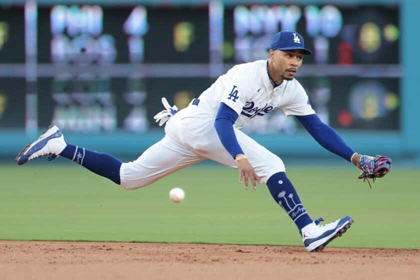 Dodgers shortstop Mookie Betts can't make the play on a single by the Rangers' Nathaniel Lowe 