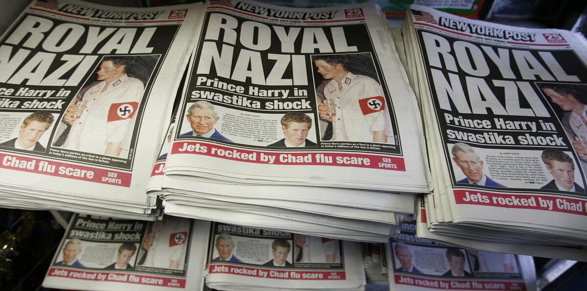 Copies of the New York Post newspaper lie on display at a newstand featuring a "Royal Nazi"