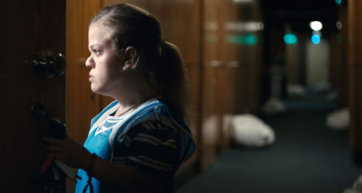 A woman with dwarfism watches the occupants of a motel room in "The Dress." 