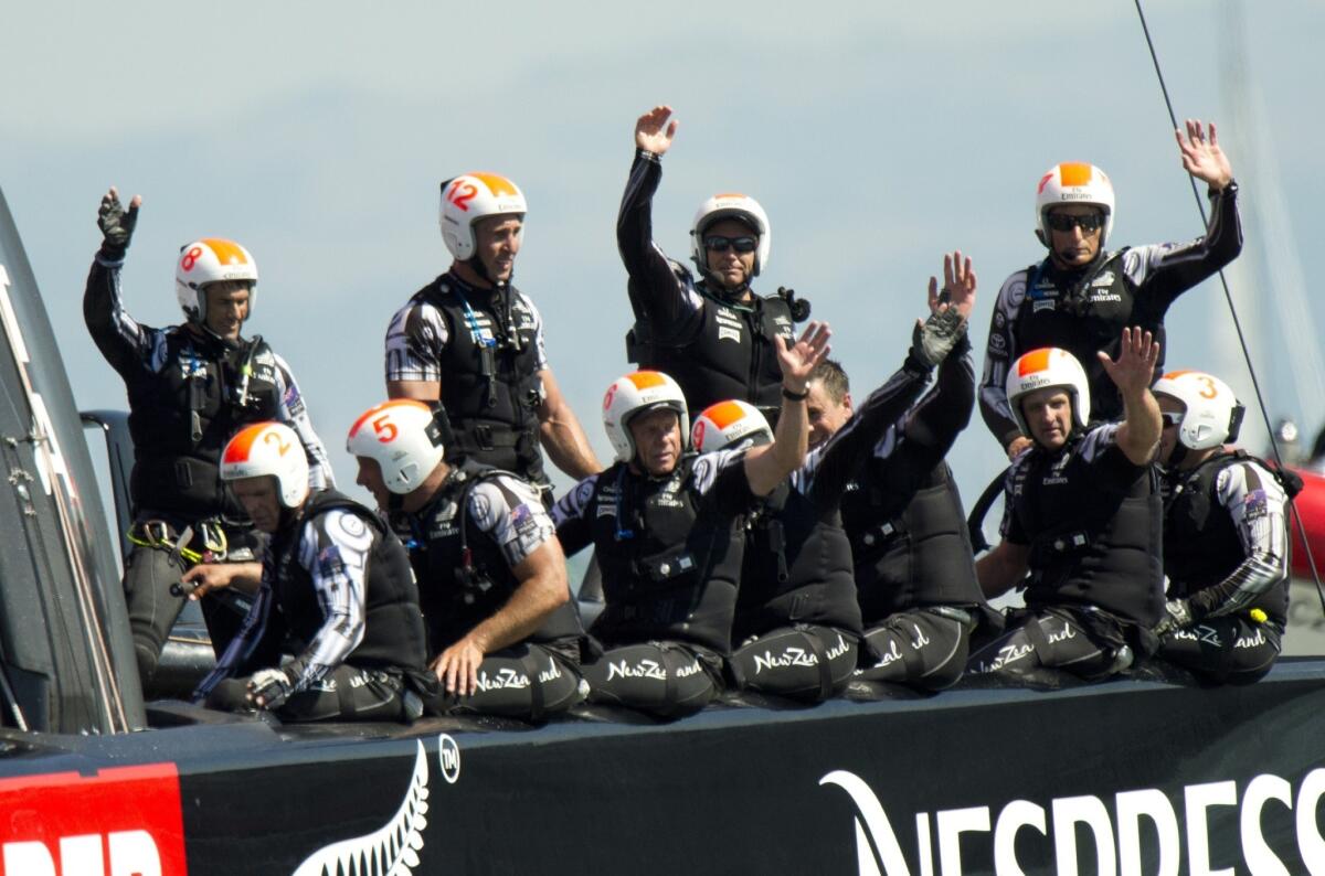 Emirates Team New Zealand crew members wave to fans after winning races six and seven of the America's Cup in San Francisco Bay on Thursday.