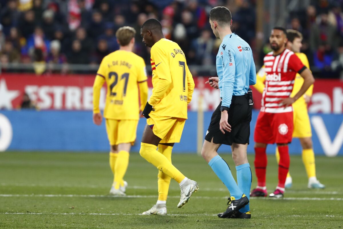 Barcelona's Ousmane Dembele, centre, walks on the pitch after being injured during the Spanish La Liga soccer match between Girona and FC Barcelona at the Montilivi stadium in Girona, Spain, Saturday, Jan. 28, 2023. (AP Photo/Joan Monfort)